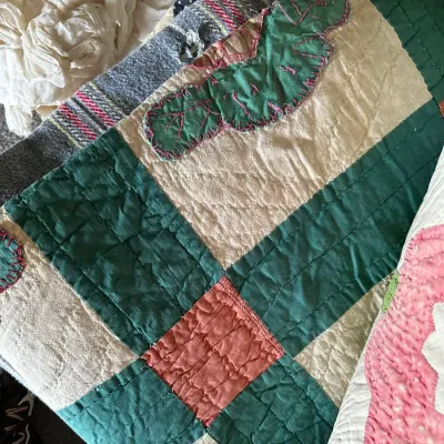Sale Photo Thumbnail #353: Handmade vintage quilt featuring green and pink appliqué and block piecing with visible hand stitching.