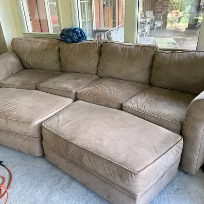 Sale Photo Thumbnail #639: Large beige microfiber sectional sofa paired with two matching oversized ottomans.
