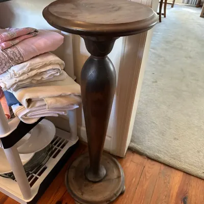 Sale Photo Thumbnail #672: Vintage dark stain wooden pedestal stand featuring a round top, urn-shaped baluster column, and footed base.