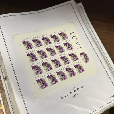 Sale Photo Thumbnail #106: Unused sheet of USPS 44-cent Love: Pansies in a Basket postage stamps, mounted in a stamp collection album binder.
