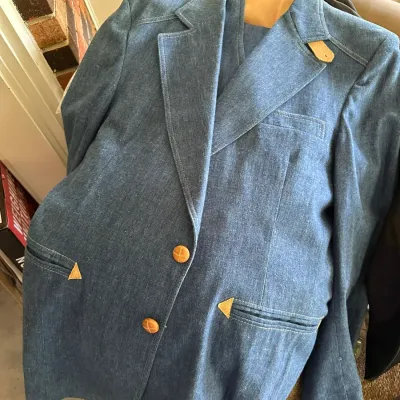 Sale Photo Thumbnail #610: Vintage 1970s blue denim western-style suit jacket, featuring wide lapels, woven leather buttons, and tan suede accent trims.