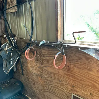 Sale Photo Thumbnail #576: Vintage farm-style hand-crank birthing or pulling tool mounted on a wooden wall alongside coiled cables.