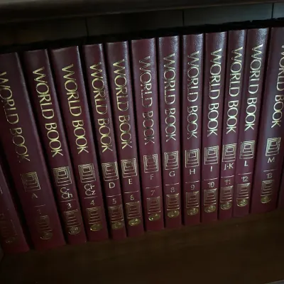 Sale Photo Thumbnail #647: Complete vintage World Book Encyclopedia set in burgundy faux-leather bindings with gilded lettering.