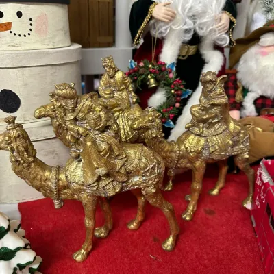 Sale Photo Thumbnail #15: Set of three vintage metallic gold-finished resin or plaster Three Wise Men figures riding camels, displayed alongside other Christmas decorations.