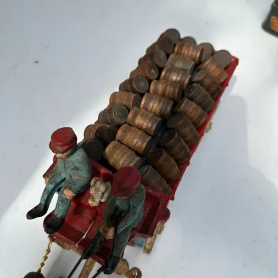 Sale Photo Thumbnail #175: Vintage cast iron horse-drawn beer wagon featuring two driver figures and a full load of miniature wooden barrels.