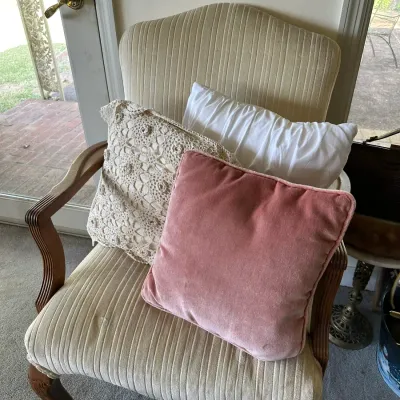Sale Photo Thumbnail #252: Vintage arm chair upholstered in off-white ribbed corduroy, featuring wooden cabriole front legs and styled with three throw pillows.