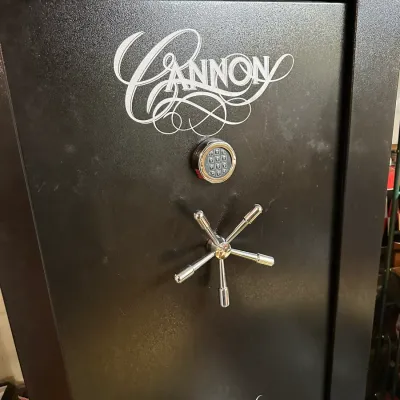 Sale Photo Thumbnail #284: Black Cannon gun safe featuring a chrome five-spoke spoke handle and an electronic keypad lock.