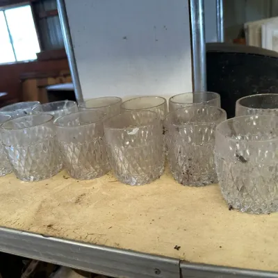 Sale Photo Thumbnail #216: Collection of vintage clear glass rocks glasses featuring a diamond-cut pressed pattern, showing surface dust and grime from storage.