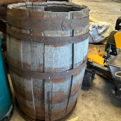 Sale Photo Thumbnail #750: Rustic weathered wooden barrel with rusted metal hoops and an open top.