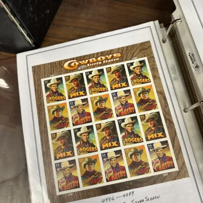 Sale Photo Thumbnail #105: USPS 'Cowboys of the Silver Screen' 44-cent commemorative postage stamp sheet housed in a collector binder sleeve, released in 2010.