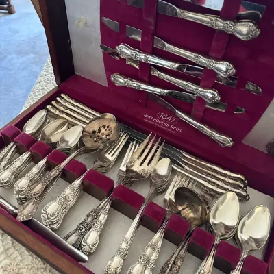 Sale Photo Thumbnail #398: Vintage 1847 Rogers Bros. silverplate flatware set housed in an ornate wooden storage chest lined with maroon velvet.