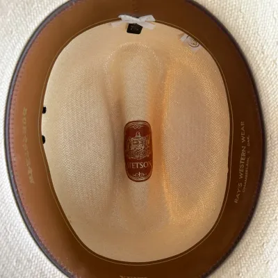 Sale Photo Thumbnail #633: Interior view of a XXXX Stetson Duralux straw cowboy hat, size 7 1/8, featuring a brown leather sweatband stamped with 'Ray's Western Wear'.