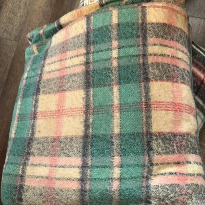 Sale Photo Thumbnail #359: Vintage plaid wool blanket in shades of green, pink, and cream, folded and stacked among other textiles.