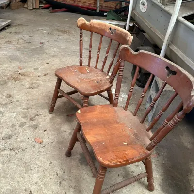 Sale Photo Thumbnail #558: Pair of vintage wooden Windsor-style dining chairs with heart cutouts in the top rail, showing heavy wear and surface scuffs.