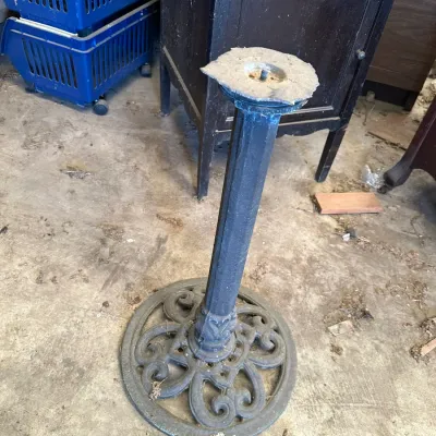 Sale Photo Thumbnail #516: Cast iron table pedestal base featuring an ornate scrollwork circular foot and a fluted column, showing light surface wear.