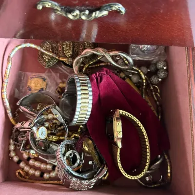 Sale Photo Thumbnail #145: Open jewelry box drawer filled with vintage costume jewelry, including metal wristwatches, beaded necklaces, and a velvet pouch.