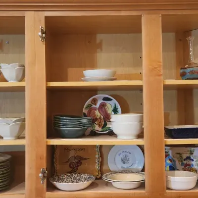 Sale Photo Thumbnail #225: Collection of assorted kitchenware, including ceramic bowls, plates, and serving dishes, displayed inside a light wood cabinet.