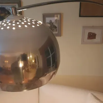 Sale Photo Thumbnail #39: Mid-century modern chrome arc floor lamp featuring a perforated dome shade.
