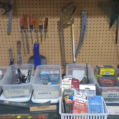 Sale Photo Thumbnail #362: Workshop organizer pegboard with hanging hand tools above clear plastic storage bins filled with screws, nails, clamps, and hardware supplies.