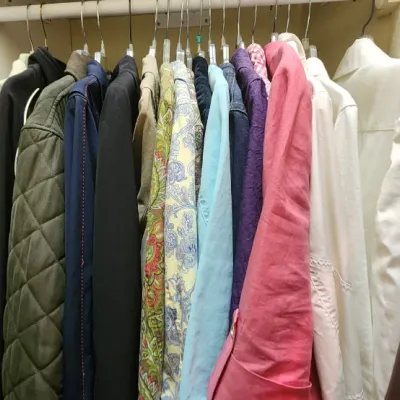 Sale Photo Thumbnail #63: Closet hanging rack featuring a collection of women's jackets, coats, and blouses, alongside shelves stored with handbags and accessories.