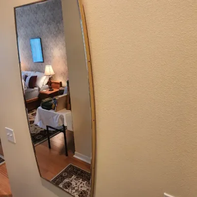 Sale Photo Thumbnail #77: Tall, full-length wall mirror with a thin metallic frame, mounted in a hallway adjacent to a bedroom and closet organizer.