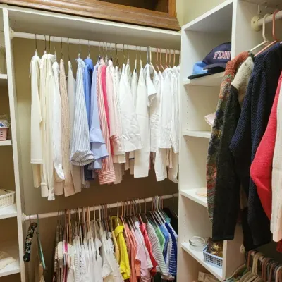 Sale Photo Thumbnail #46: Walk-in closet filled with men's and women's clothing, including knit sweaters, button-down shirts, and accessories stored on shelving units.