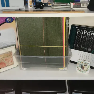 Sale Photo Thumbnail #288: Office supplies on white shelves, including a box of 500 #10 envelopes, PaperDirect stationary folders, craft felt sheets, and a framed art print.