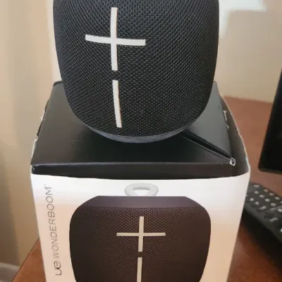 Sale Photo Thumbnail #163: Ultimate Ears Wonderboom portable Bluetooth speaker in black, sitting atop its original retail packaging.