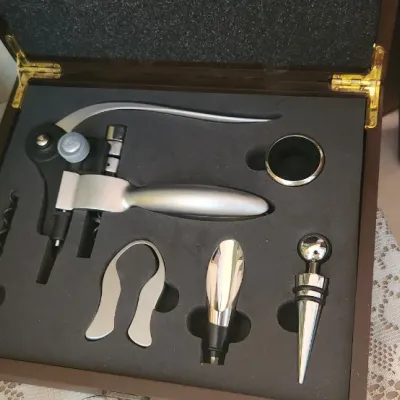 Sale Photo Thumbnail #145: Executive wine opener gift set in a wooden display box, shown alongside vintage liquor bottles and collectible household items.