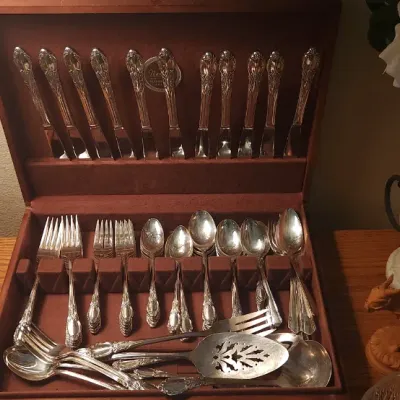 Sale Photo Thumbnail #3: Vintage silver-plated flatware set in a velvet-lined wooden storage chest, displayed alongside decorative table lamps and home decor.