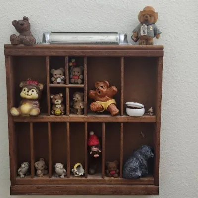 Sale Photo Thumbnail #299: Vintage wooden wall-mounted shadow box display shelf filled with small bear and animal figurines.