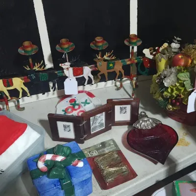 Sale Photo Thumbnail #330: Collection of holiday decorations, including a metal reindeer candleholder, small tri-fold picture frames, a Christmas gift basket, and various ornaments.