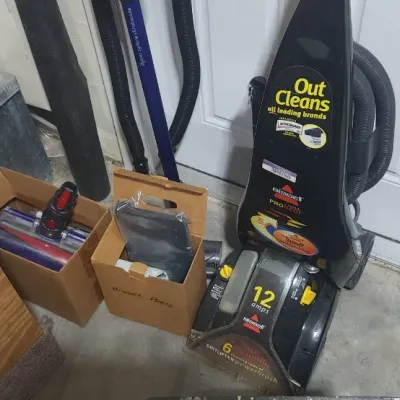 Sale Photo Thumbnail #356: Bissell ProHeat 12 amp carpet cleaner alongside boxes containing additional attachments and vacuum accessories.
