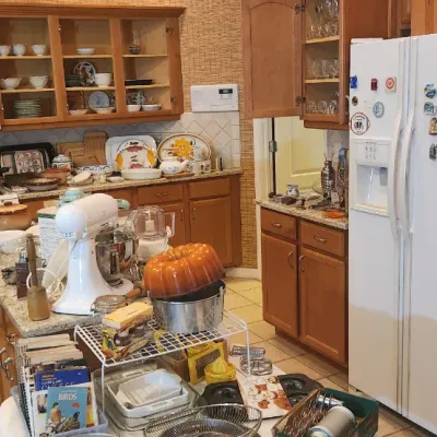 Sale Photo Thumbnail #230: Kitchen full of household goods for sale, including a KitchenAid stand mixer, bundt pans, glassware, cookware, and minor appliances.