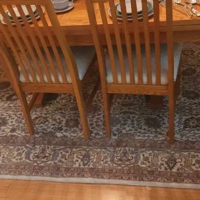 Sale Photo Thumbnail #16: Large oriental-style area rug featuring a muted floral floral and scroll motif in neutral tones, shown beneath a dining table set.