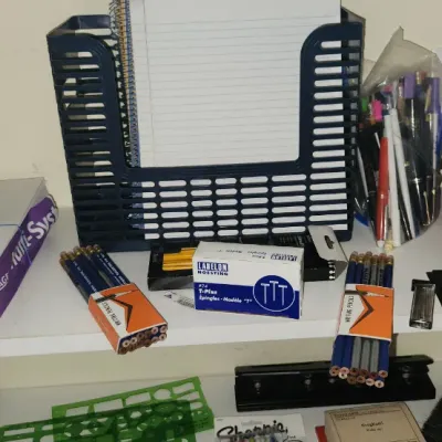 Sale Photo Thumbnail #283: Assorted office and desk supplies on a white shelf, including printer paper, writing utensils, file folder labels, and organizers.