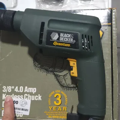 Sale Photo Thumbnail #364: Black & Decker Quantum 3/8-inch 4.0 amp corded electric drill with a keyless chuck, resting on its original retail box.