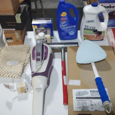 Sale Photo Thumbnail #383: Assortment of household cleaning supplies, including floor cleaners, a Glass Wizard tool, work gloves, tapes, and a handheld cordless vacuum.