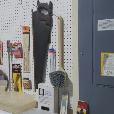 Sale Photo Thumbnail #352: Workshop wall organization display featuring hanging hand saws, small hardware packages, brushes, and clear plastic storage organizers next to a breaker panel.