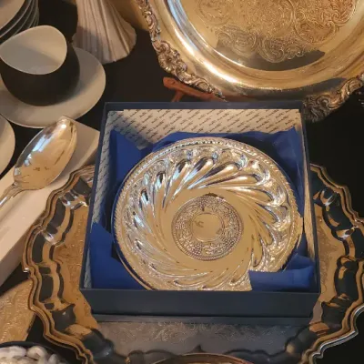 Sale Photo Thumbnail #14: Collection of tableware including a boxed silver-plated swirl dish, silver serving trays and utensils, gold-tone pineapple demitasse spoons, and novelty guitarist plates.