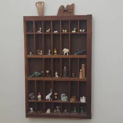 Sale Photo Thumbnail #307: Vintage wall-mounted wooden shadow box shelf filled with an assortment of miniature ceramic and glass figurines.