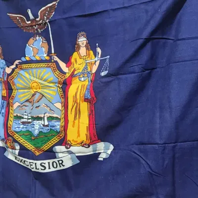 Sale Photo Thumbnail #324: State of New York flag featuring the state coat of arms printed on a dark blue background with canvas heading and brass grommets.