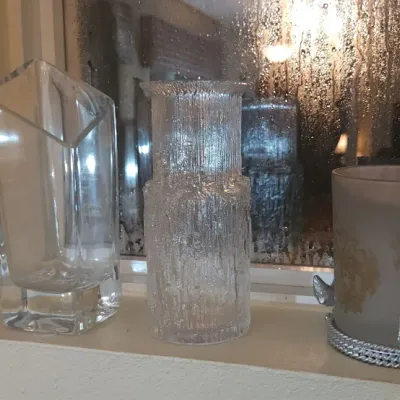Sale Photo Thumbnail #160: Collection of three decorative glass pieces, including a modern angular vase, a textured Scandinavian-style bark glass vase, and a frosted glass candle holder with a metallic base.