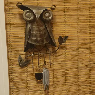 Sale Photo Thumbnail #252: Rustic metal owl wall-mounted key holder with branch design and hooks.
