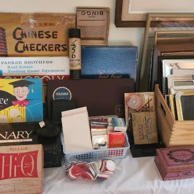 Sale Photo Thumbnail #80: Collection of vintage board games and picture frames, including vintage Monopoly, Yahtzee, Chinese Checkers, Pictionary, and an assortment of metallic photo frames in a wooden crate.
