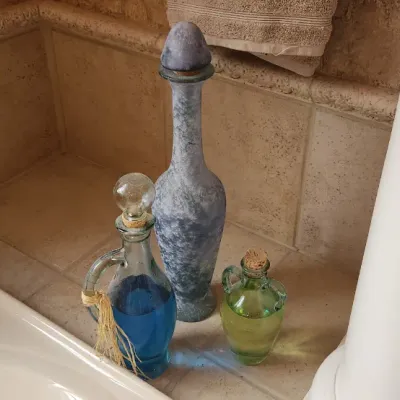 Sale Photo Thumbnail #121: Collection of three decorative glass bottles and decanters in varied sizes, finishes, and colors.