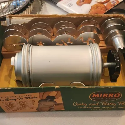 Sale Photo Thumbnail #233: Vintage Mirro aluminum cooky and pastry press set with multiple design discs, complete in original retail box.