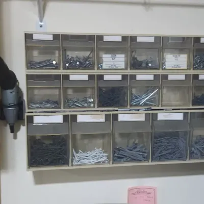 Sale Photo Thumbnail #358: Wall-mounted plastic hardware organizer filled with various screws, nails, and fasteners.