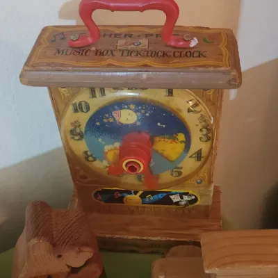 Sale Photo Thumbnail #22: Vintage Fisher-Price Music Box Tick-Tock Clock toy with red plastic handle and wind-up dial.