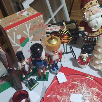 Sale Photo Thumbnail #329: Collection of holiday decorations including wooden nutcrackers, Santa Claus figurines, Christmas tree candles, and a festive gift box.